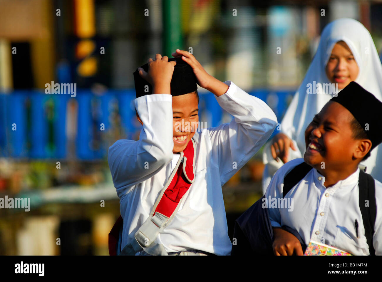 BRUNEI, Bandar Seri Begawan. Retrato de colegiales musulmana asiática  vistiendo la camiseta blanca, jugando Fotografía de stock - Alamy