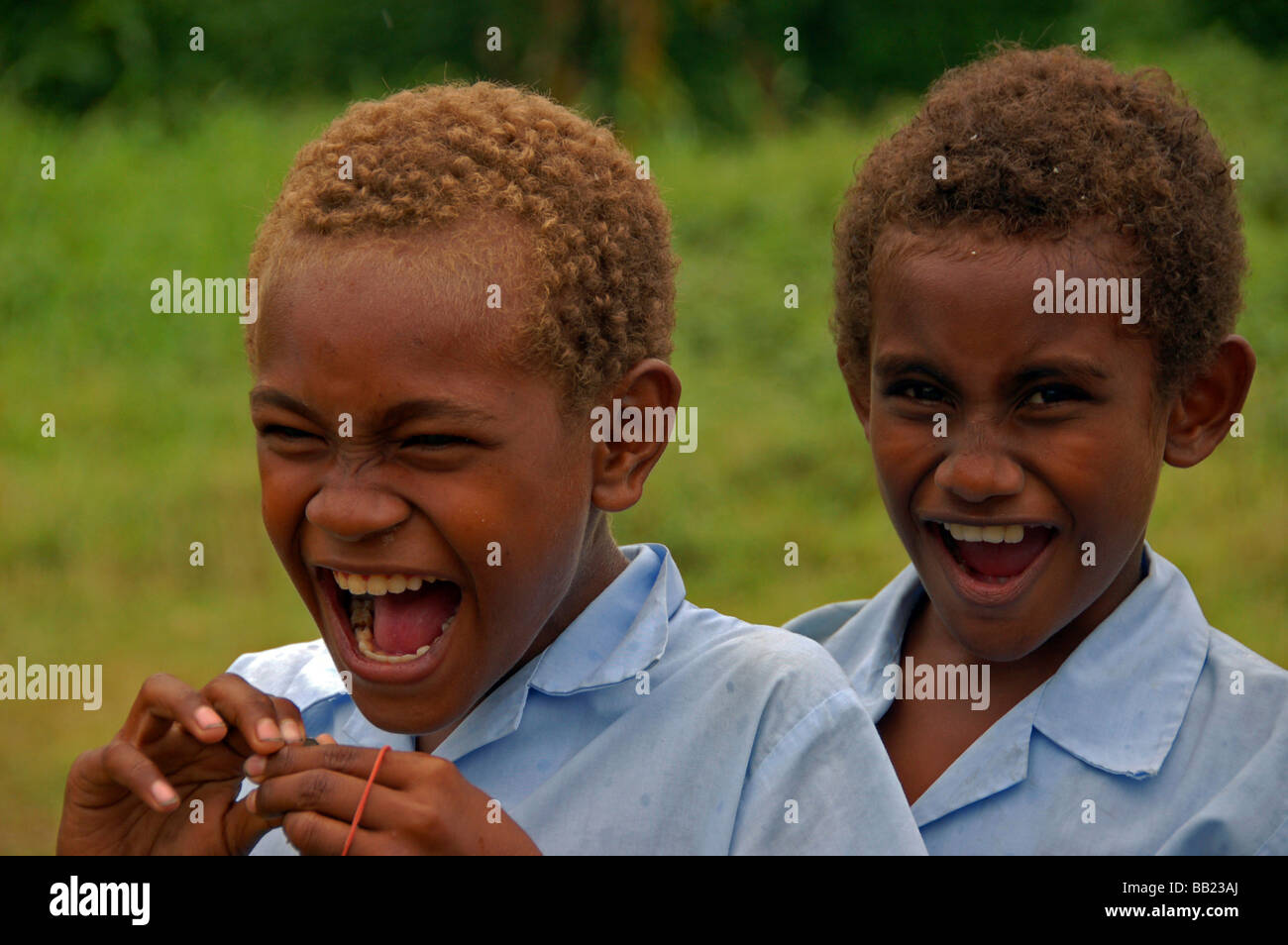 Las Islas Salomón. Pareja de chicos melanesios con breves Brown & rubio  cabello frizzy, vistiendo camisetas azules de luz Fotografía de stock -  Alamy