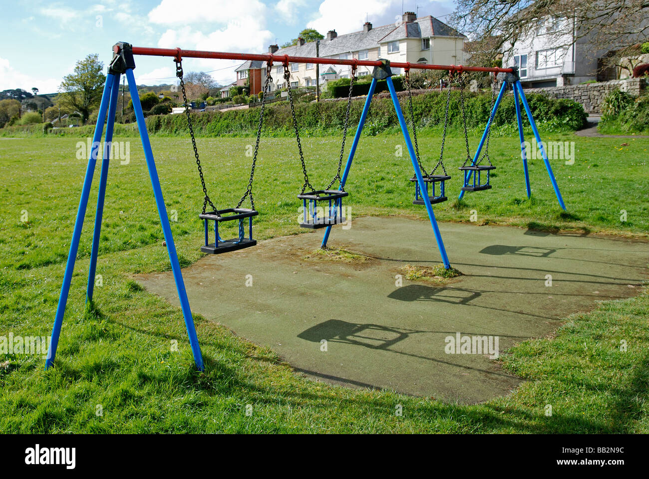 Parque infantil con columpio para bebés y deslice cerca de casas Fotografía  de stock - Alamy