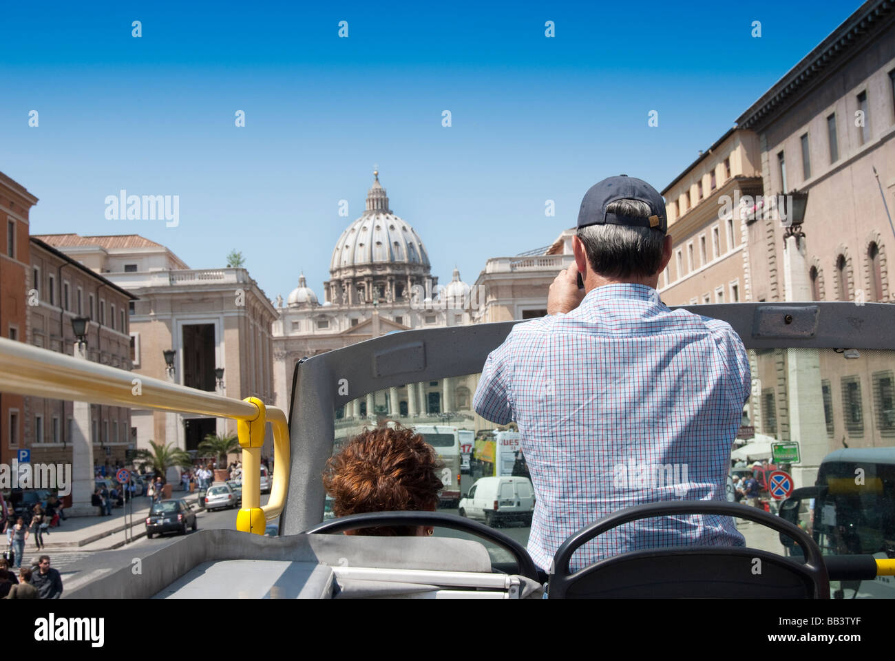 El hombre toma una foto del Vaticano desde un autobús con el techo abierto. Foto de stock