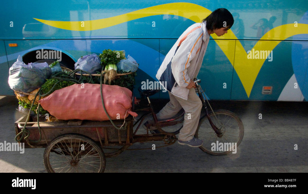 Una persona con una bicicleta de transporte de mercancías de la provincia  de Yunnan, en China Fotografía de stock - Alamy