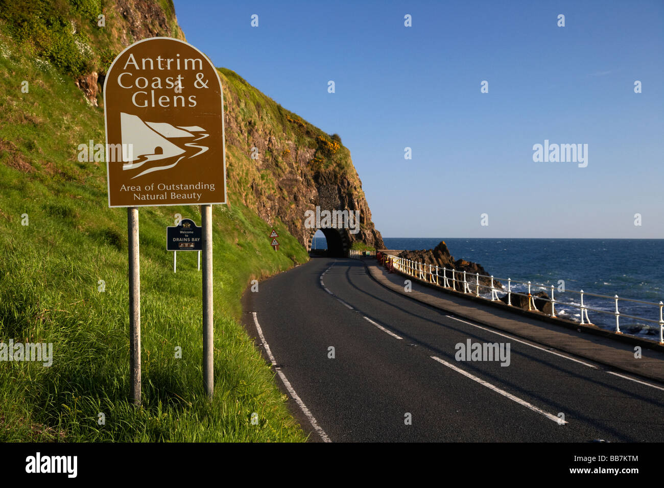 Y cañadas de Antrim signo en A2 ruta costera causeway coast road pasa a través del arco negro fuera de Larne Foto de stock