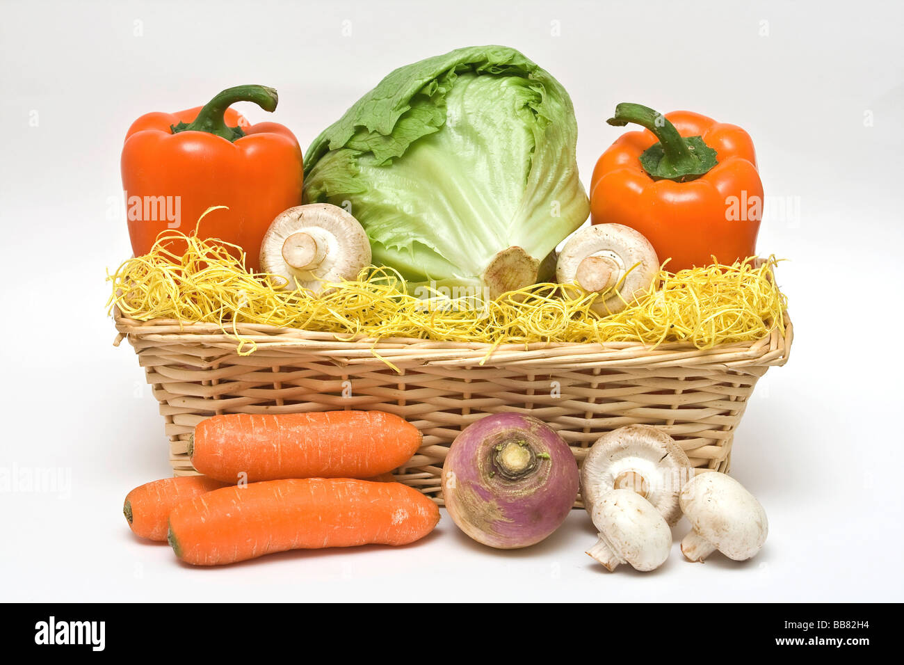 Color cesta de verduras, lechuga iceberg, naranja pimientos, setas, zanahorias frescas, raddish redonda Foto de stock