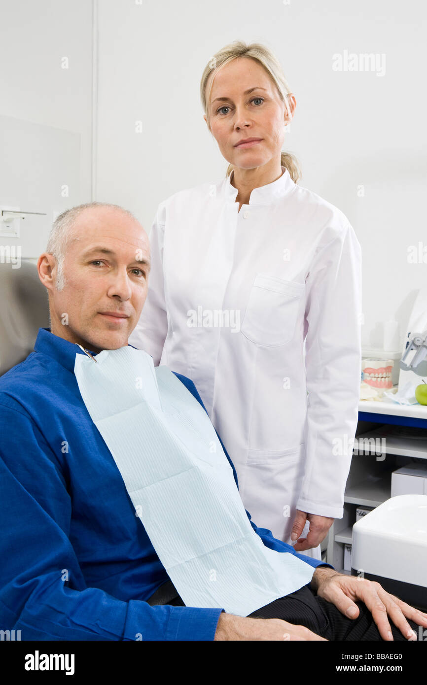 Un asistente dental y un paciente en una sala de examen dental Foto de stock