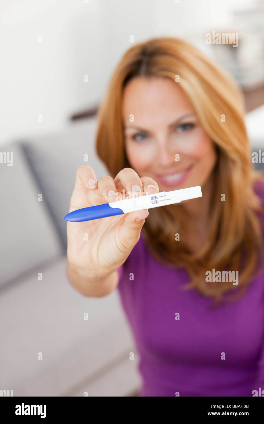 Mujer joven mostrando test de embarazo Foto de stock