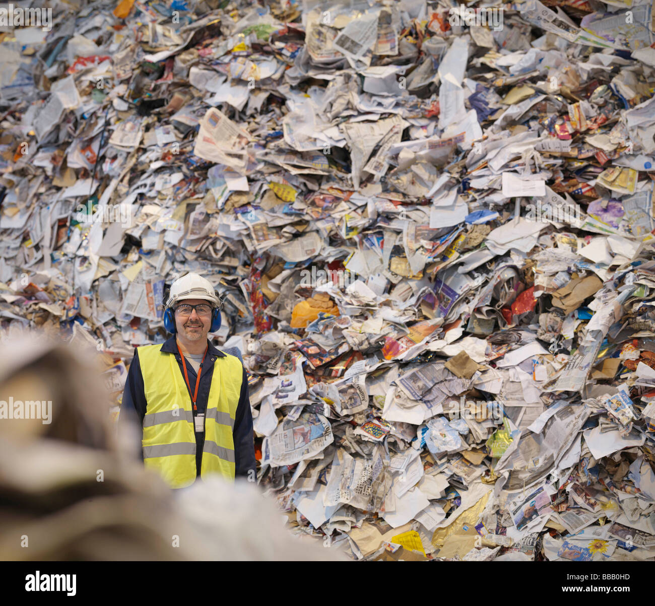 Trabajador con papel en planta de reciclaje Foto de stock