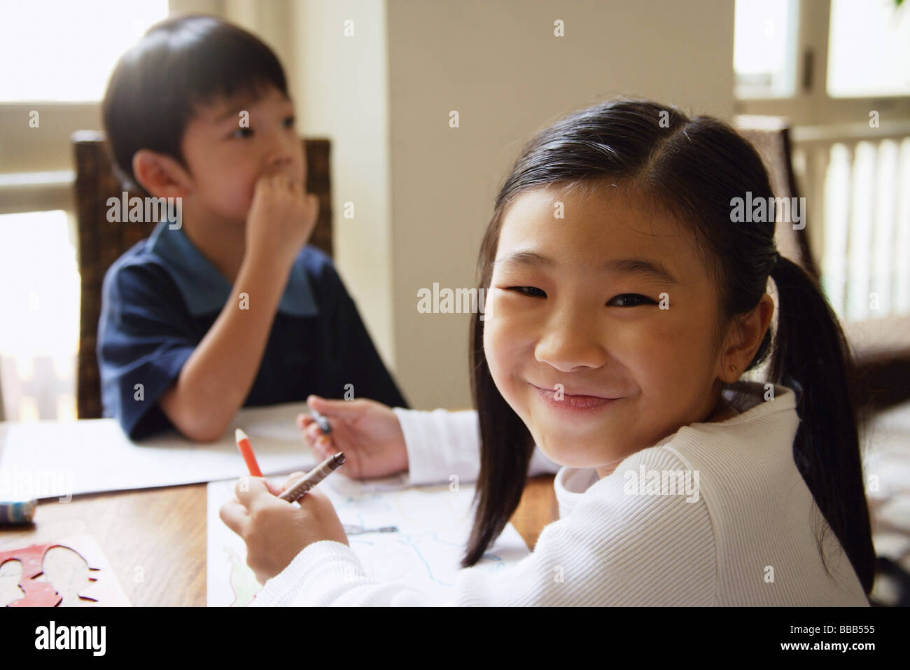 Niños Sentados En La Mesa Chica Volviendo A Sonreír A La Cámara Fotografía De Stock Alamy 9439