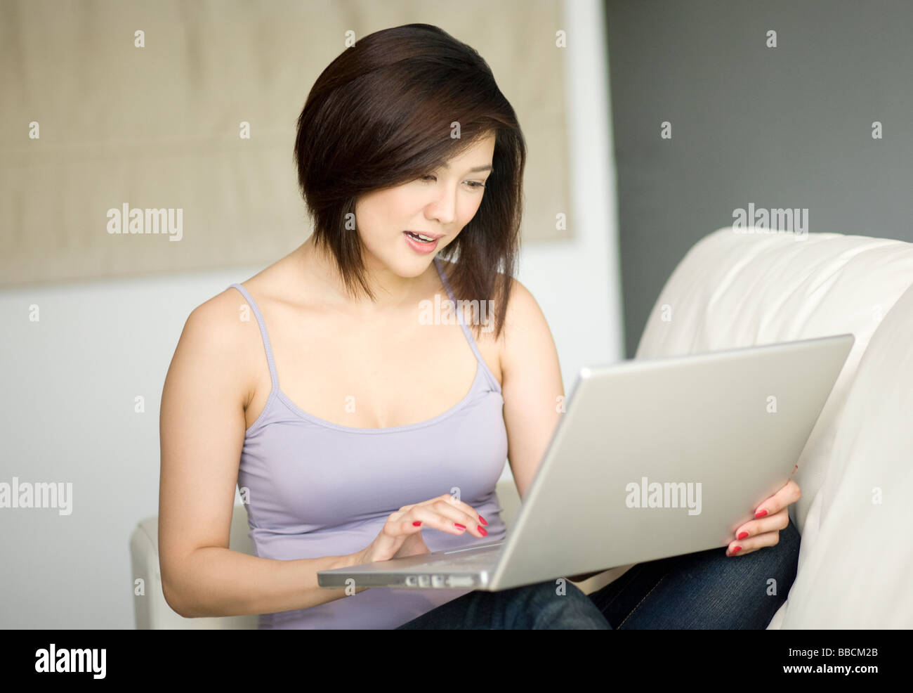 Las hembras jóvenes utilizando el portátil en su casa Foto de stock