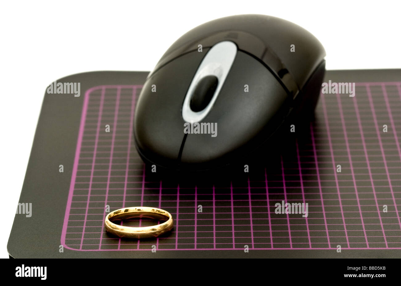 Ratón láser inalámbrico sobre una alfombrilla de ratón de entramado  apuntando hacia un anillo de bodas Fotografía de stock - Alamy