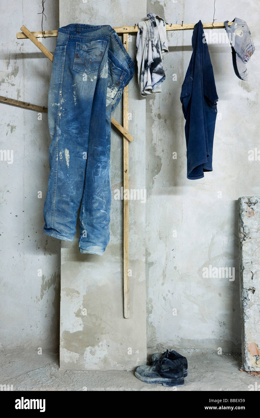 Jeans, camiseta y sombrero colgando del perchero Foto de stock