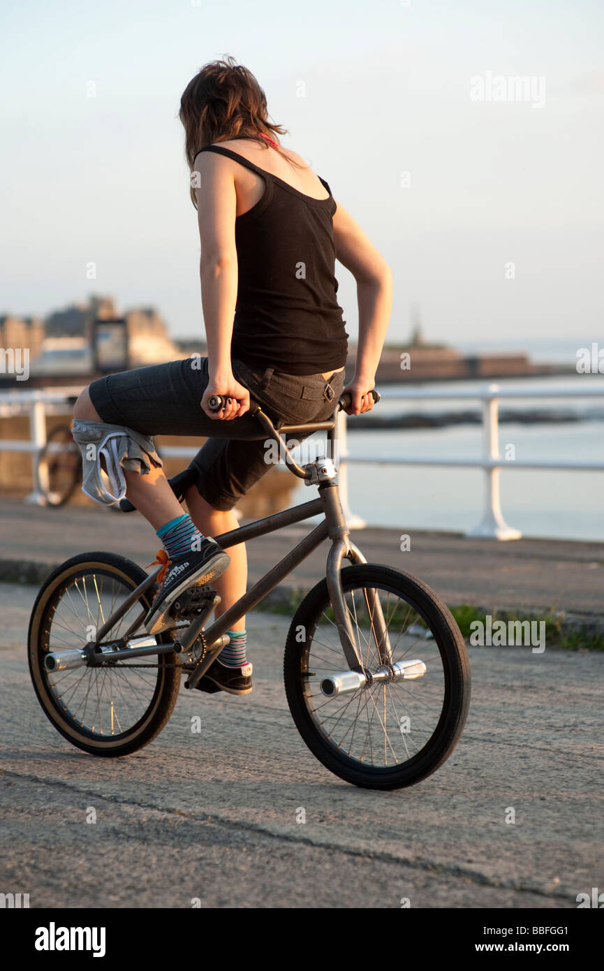 Una mujer joven de flatland BMX stunt rider montando su bicicleta hacia  atrás Gales Aberystwyth UK Fotografía de stock - Alamy