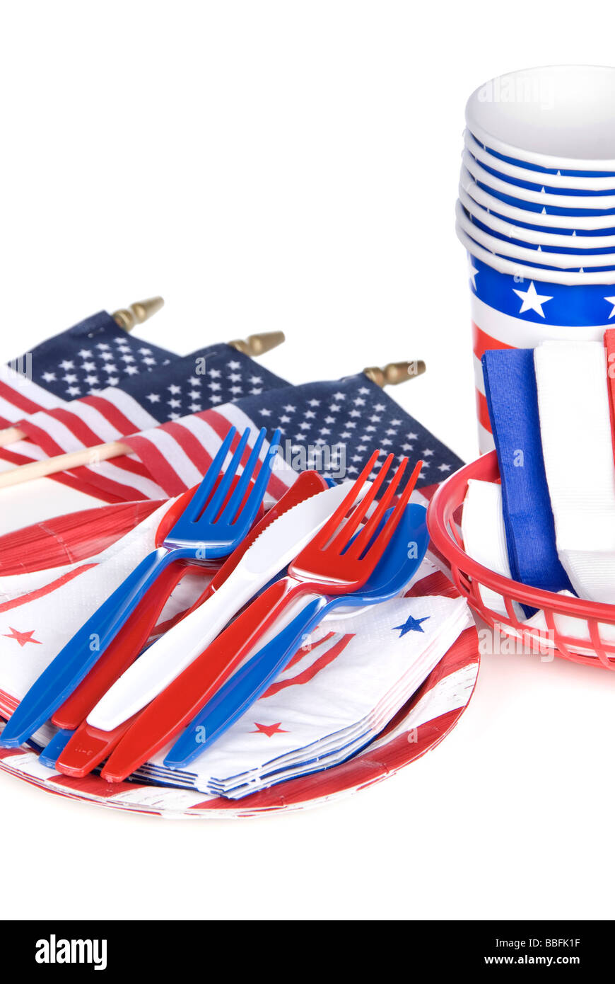 Julio cuarto utensilios patriótico incluyendo horquillas de plástico cuchillos cucharas servilletas platos y vasos sobre un fondo blanco. Foto de stock