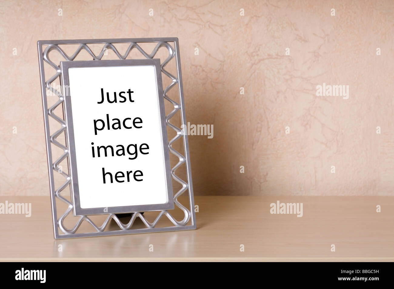 Marco de fotos metálico sobre un estante de madera Foto de stock