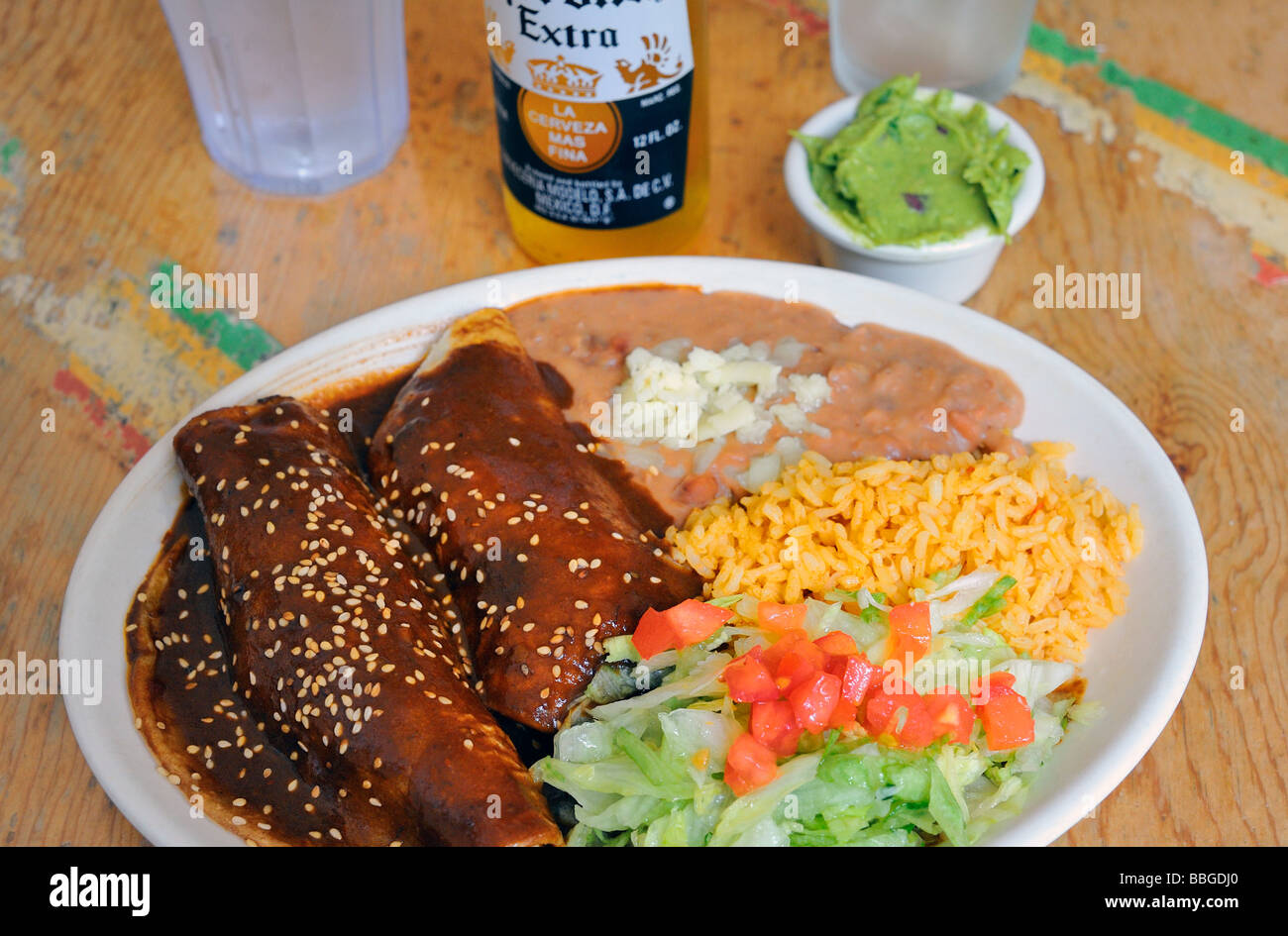 Enchiladas de pollo con mole poblano salsa y arroz y frijoles con queso y  una orden de guacamole Fotografía de stock - Alamy