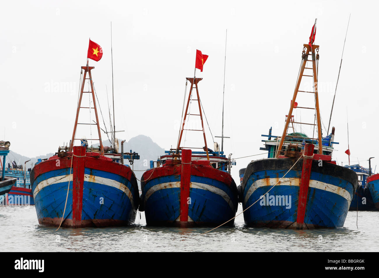 Tradicional vietnamita [barcos] con arcos pintados de rojo y azul, amarrado  y enarbolan la bandera nacional, [el] La Bahía de Halong, Vietnam  Fotografía de stock - Alamy