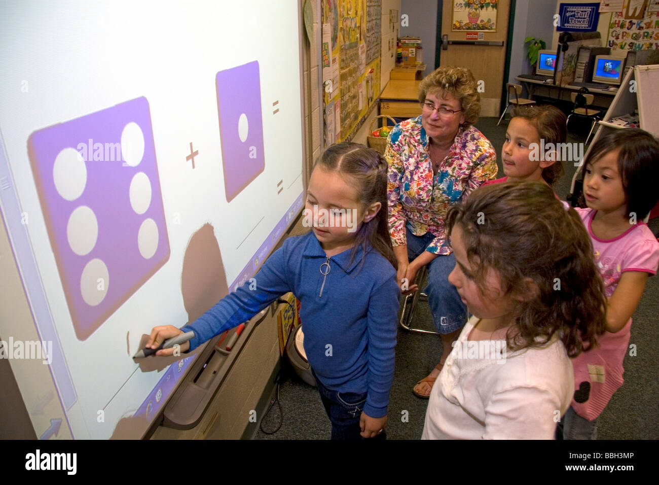 Los estudiantes de kindergarten utilizar una pizarra interactiva en el aula de una escuela pública en Boise, Idaho, EE.UU. MR Foto de stock
