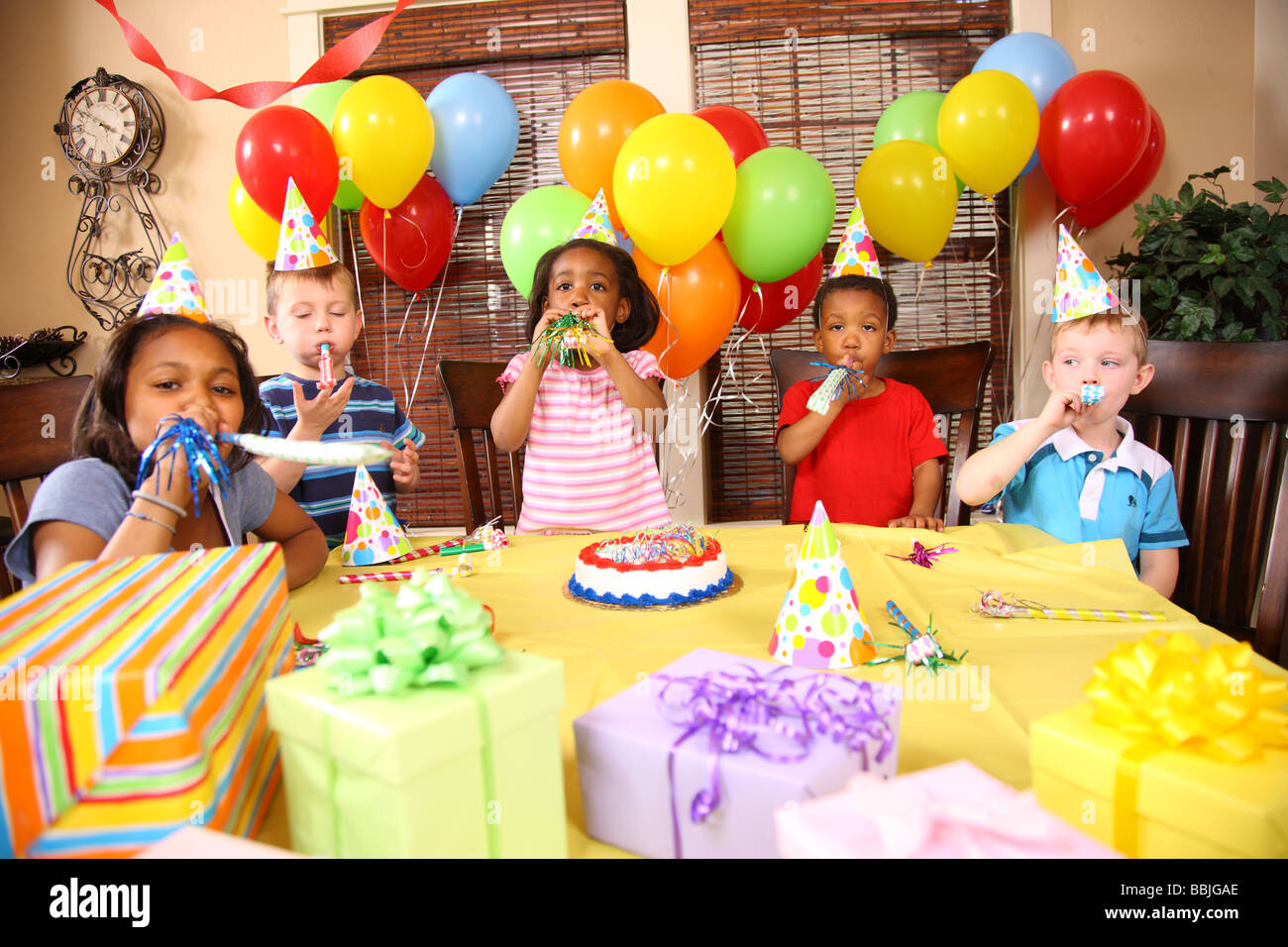 Los niños en la fiesta de cumpleaños de soplar matasuegras Foto de stock