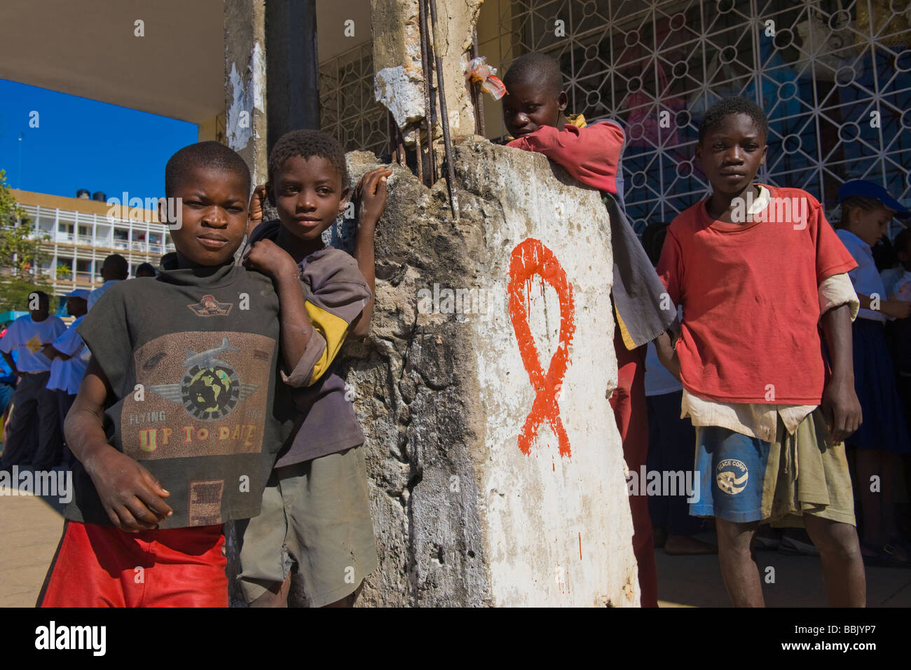 Los niños de la calle de pie en un pilar pintado con VIH SIDA ribbon Quelimane, Mozambique Foto de stock