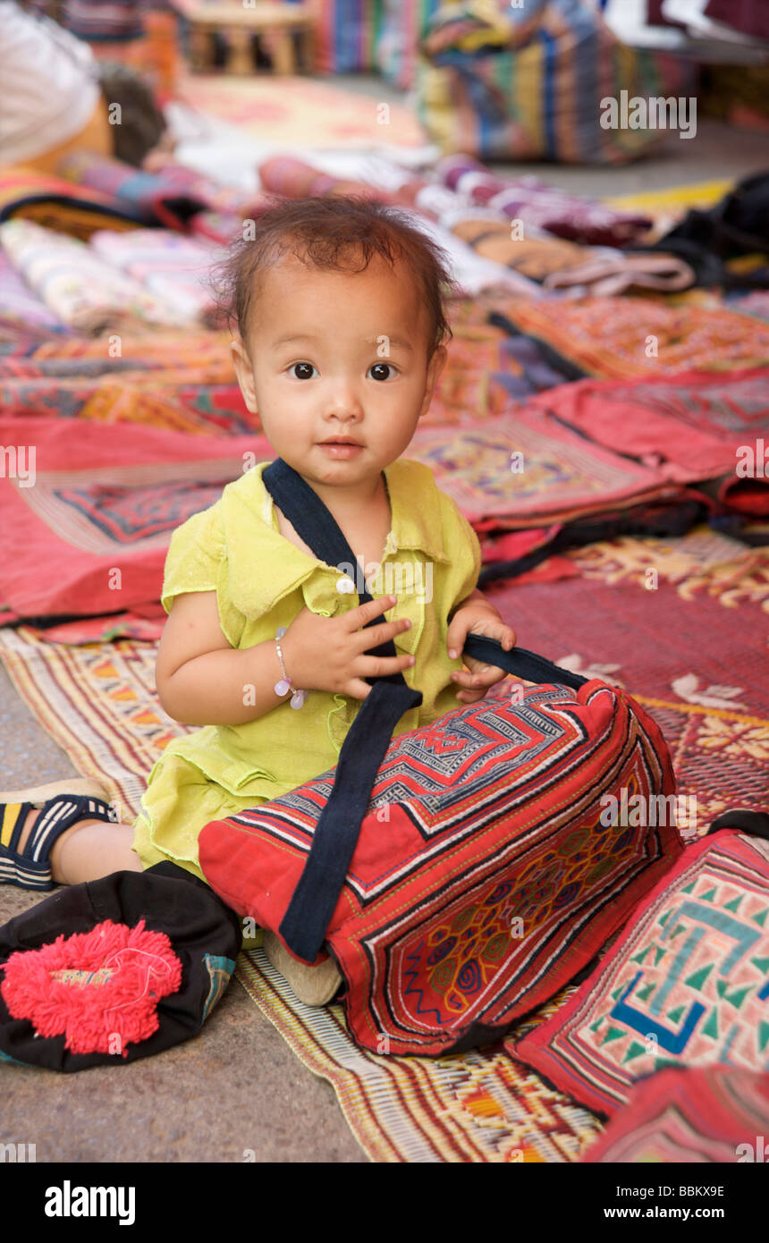 Una niña juega con sus madres calar en el mercado nocturno de Luang Prabang Laos Foto de stock