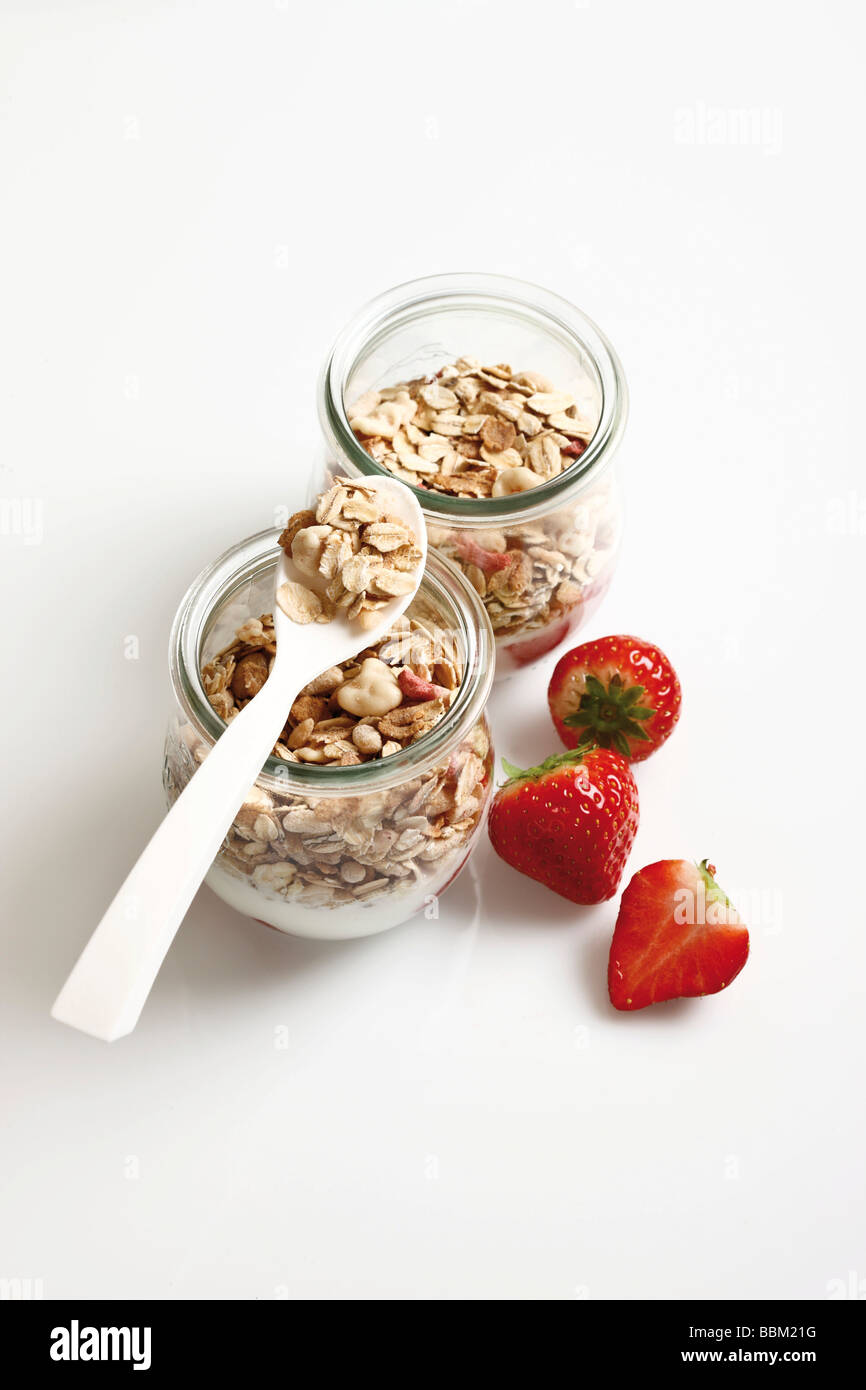 Muesli con yogur y fresas en pequeños frascos de vidrio Foto de stock
