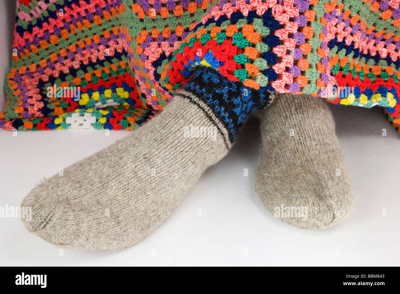 Pies en calcetines tejidos de lana en crochet manta Foto de stock