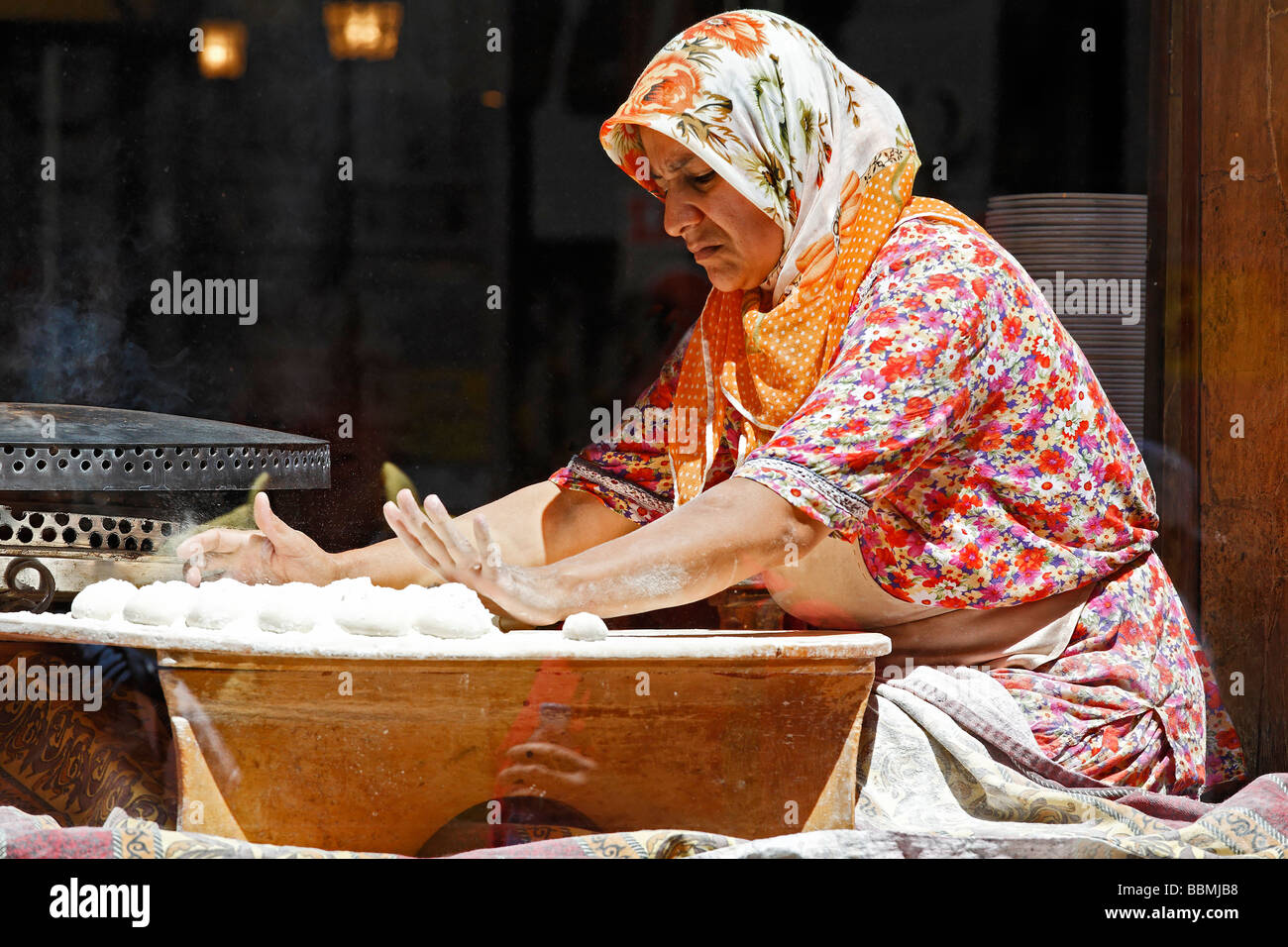 Mujer turca con un pañuelo de masa para rollos de pan, mirar por la ventana de un restaurante, de compras, la calle Istiklal Caddes Foto de stock