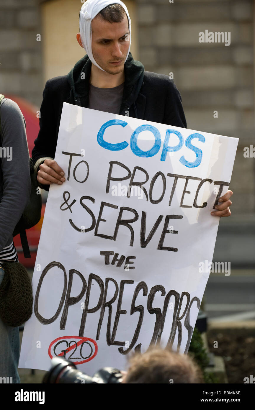 Hombre con un anti-banner de la policía cuando los manifestantes acuden a la ciudad antes de la cumbre del G-20 de líderes mundiales, el 1 de abril de 2009 Foto de stock