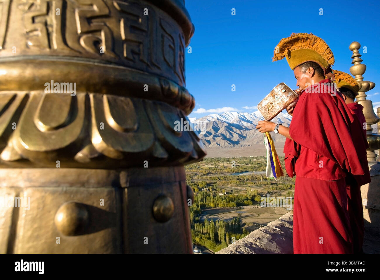 Thiksey Gompa, Ladakh, Jammu y Cachemira, en la India; y monje budista soplando caracola trompeta Foto de stock