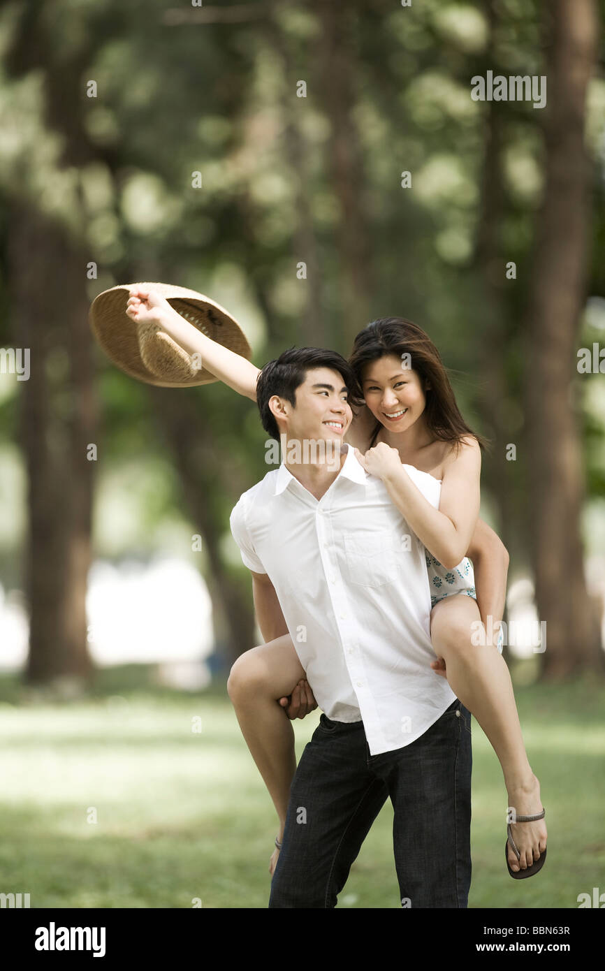 Hombre Mujer dando a cuestas en el parque Foto de stock