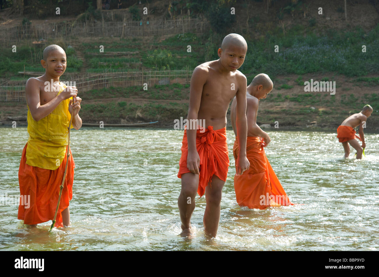 Un grupo de monjes budistas novato jugando en el río Nam Khan, en Luang Prabang, Laos Foto de stock