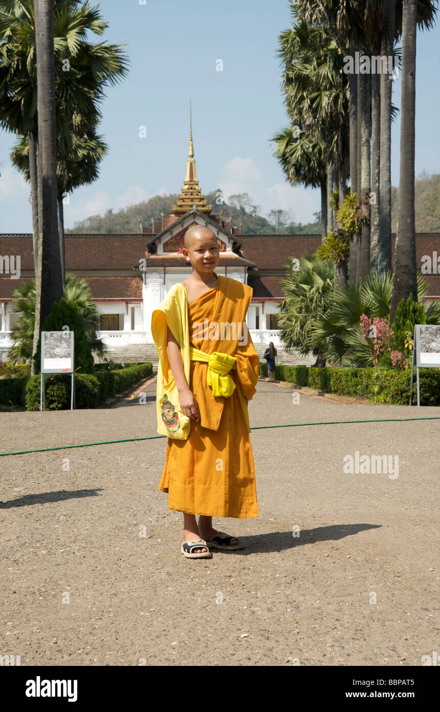 Una joven novicia monjes budistas se encuentra enfrente del antiguo palacio real de Luang Prabang Laos Foto de stock