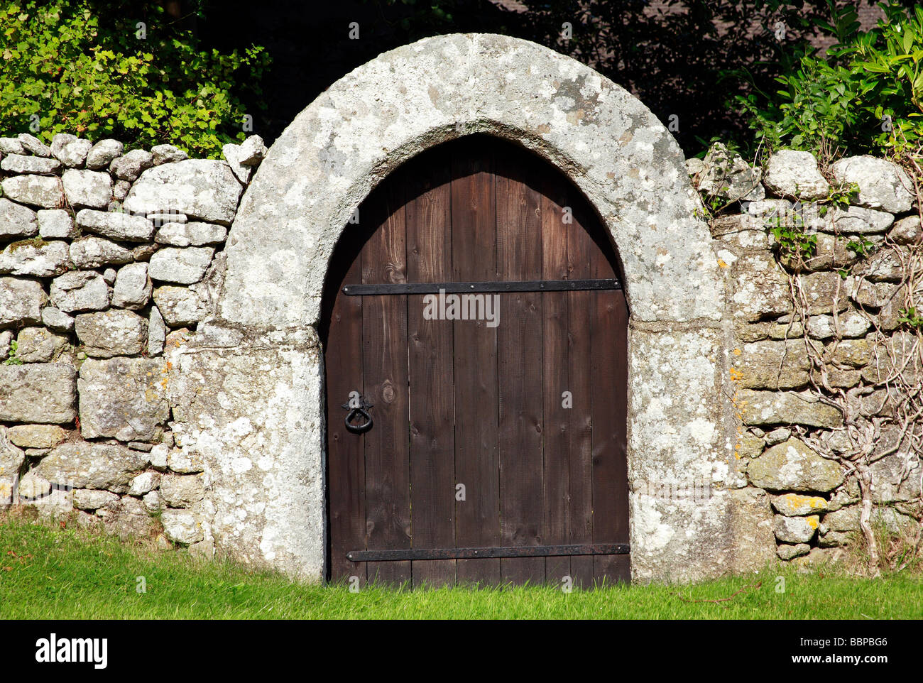 Puerta de madera en la pared de piedra grande Foto de stock