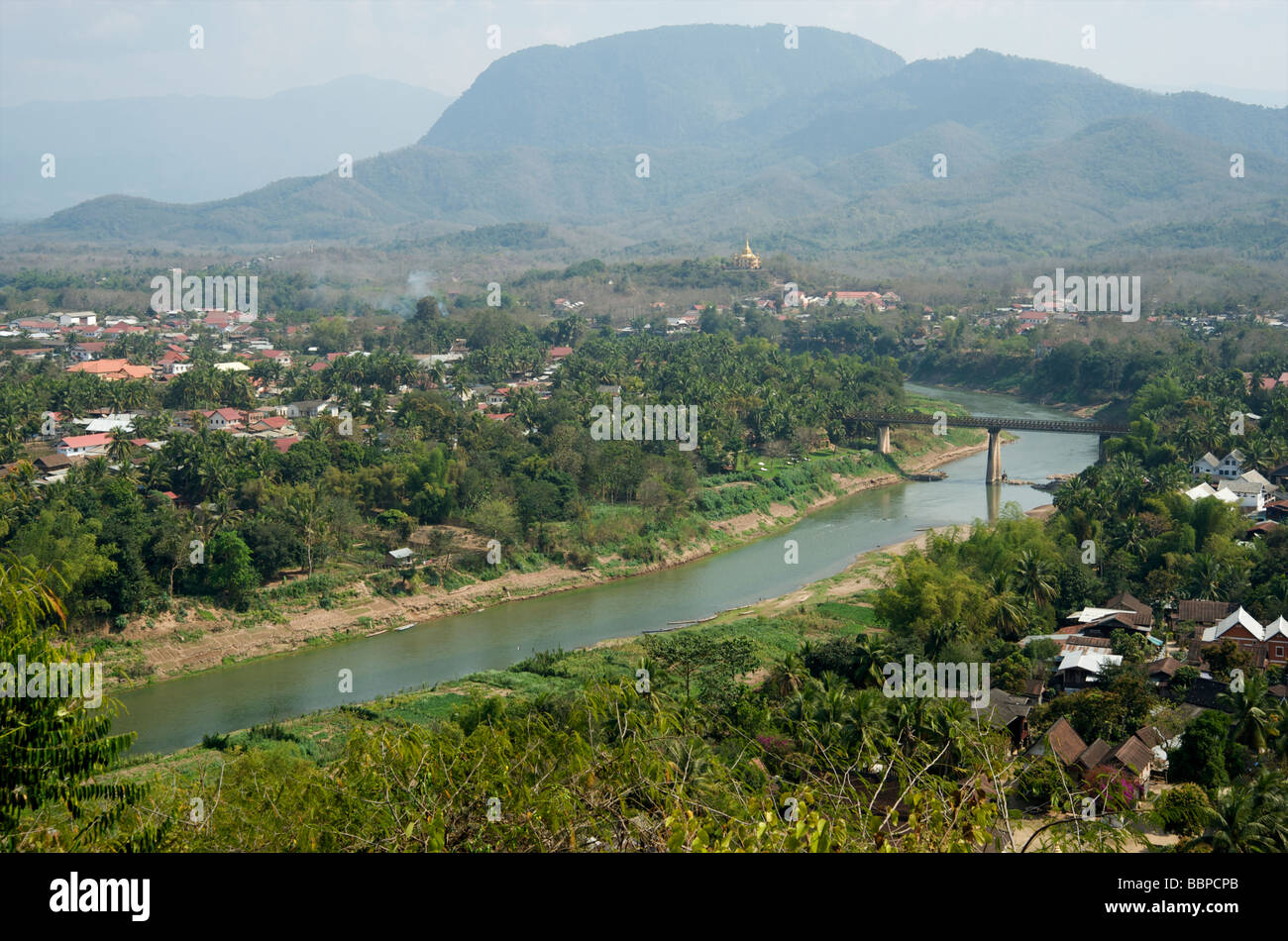 Vista de Luang Prabang Sisavangvong y el puente sobre el río Nam Khan, que templo de Wat Chomsi en Cerro de Phou Si Laos Foto de stock