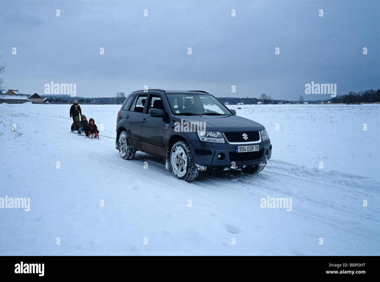 Polonia montañas Swietokrzyskie Suzuki Grand Vitara remolcar trineos con niños Foto de stock