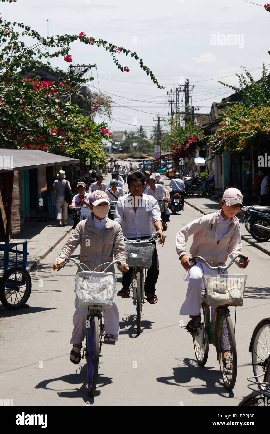 De la escuela a las niñas] andando en bicicleta vistiendo blanco  tradicional "ao dai" uniformes y "máscaras", "Hoi An, Vietnam Fotografía de  stock - Alamy