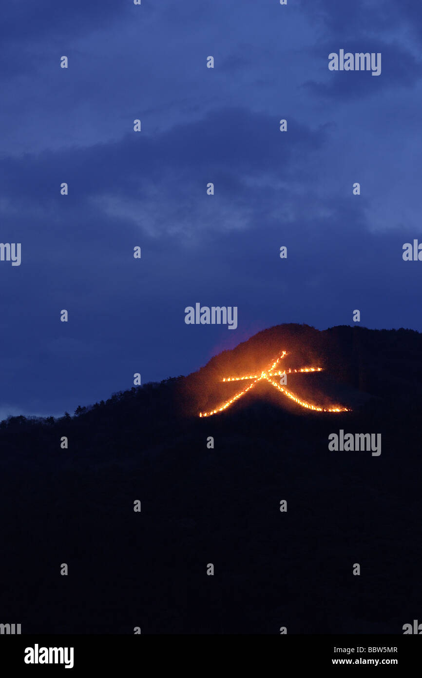 Signo de fuego controlado japonés iluminando una colina Foto de stock