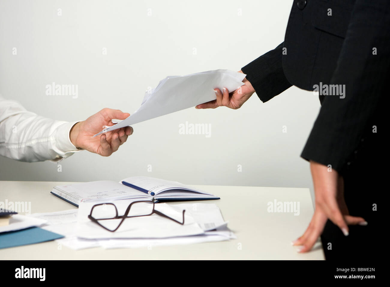 Entrega de documentos a través de la empresaria a un colega, en la oficina  Fotografía de stock - Alamy