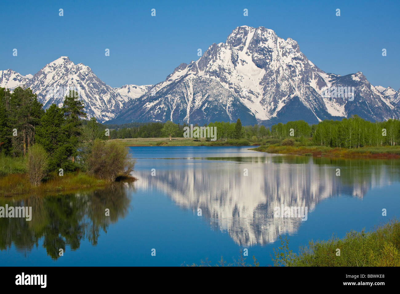 Reflejos en el lago de las montañas cubiertas de nieve en el parque nacional Grand Teton en Wyoming Foto de stock