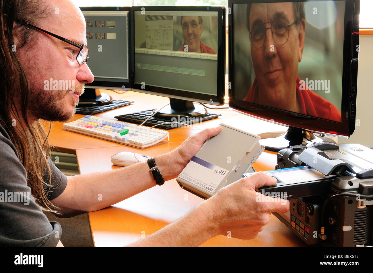 Asistente editor carga cintas en un ávido offline edit suite mediante una platina de cinta HDCAM-SR. Foto de stock