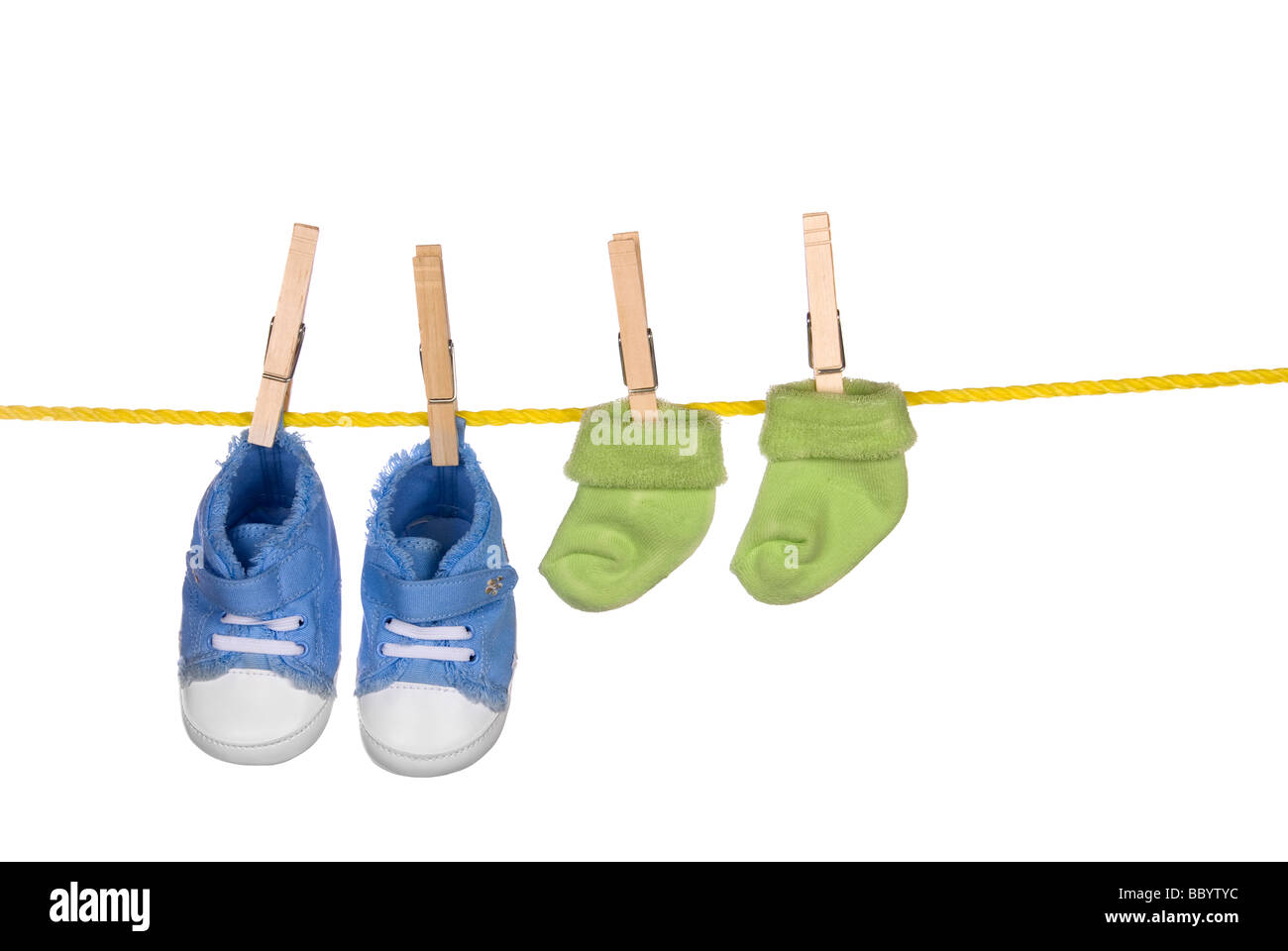 Un par de zapatos y calcetines bebé colgando de un tendedero Foto de stock