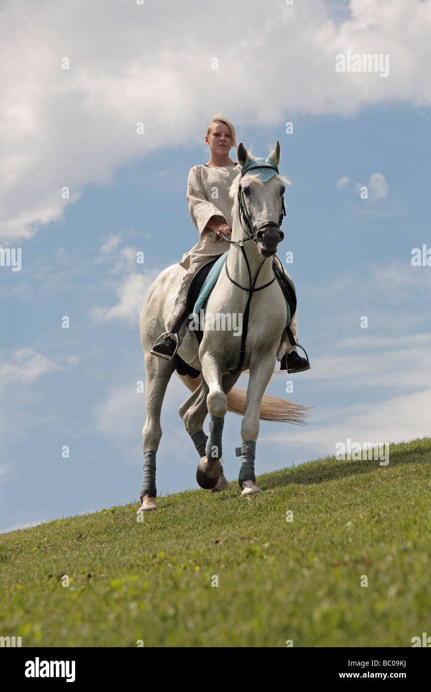 Chica cabalgatas en la colina Foto de stock