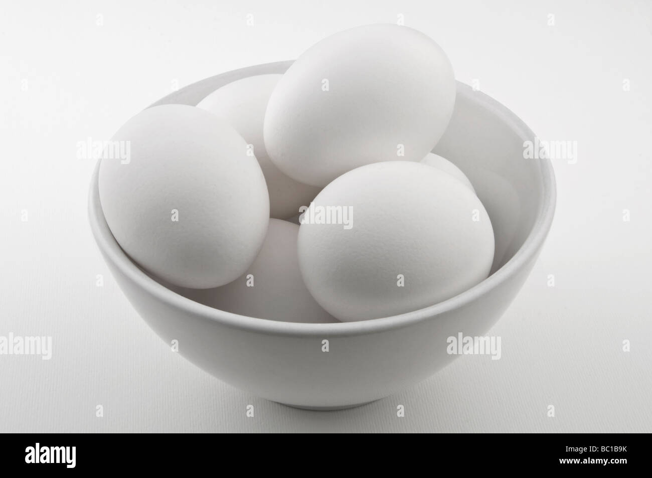 Los huevos de pollo en un recipiente blanco. Foto de stock