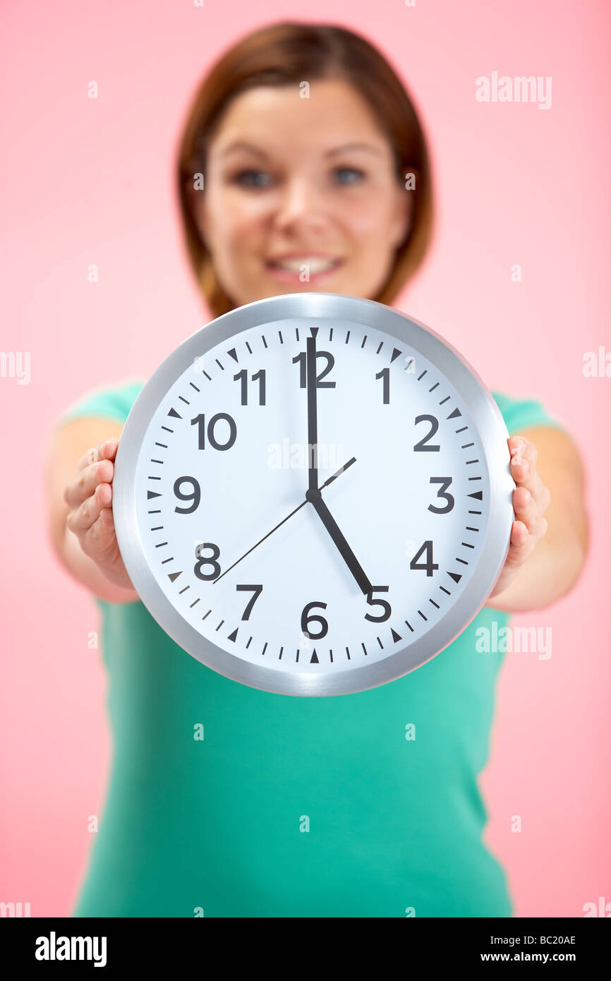 Mujer sosteniendo reloj mostrando 5 O'Clock Foto de stock