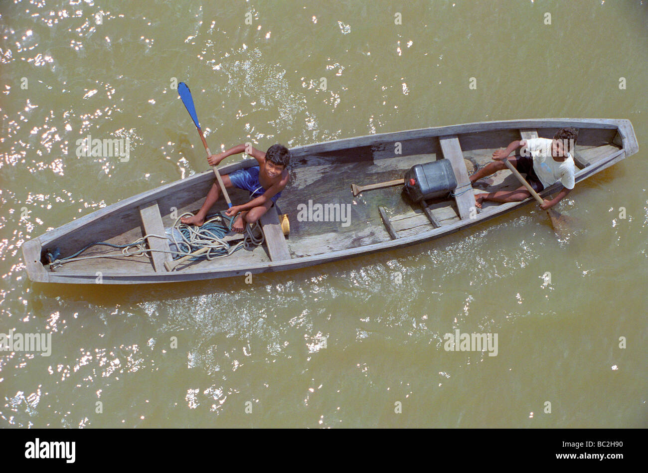 Los niños remar en canoa por el Río Amazonas en Brasil Foto de stock