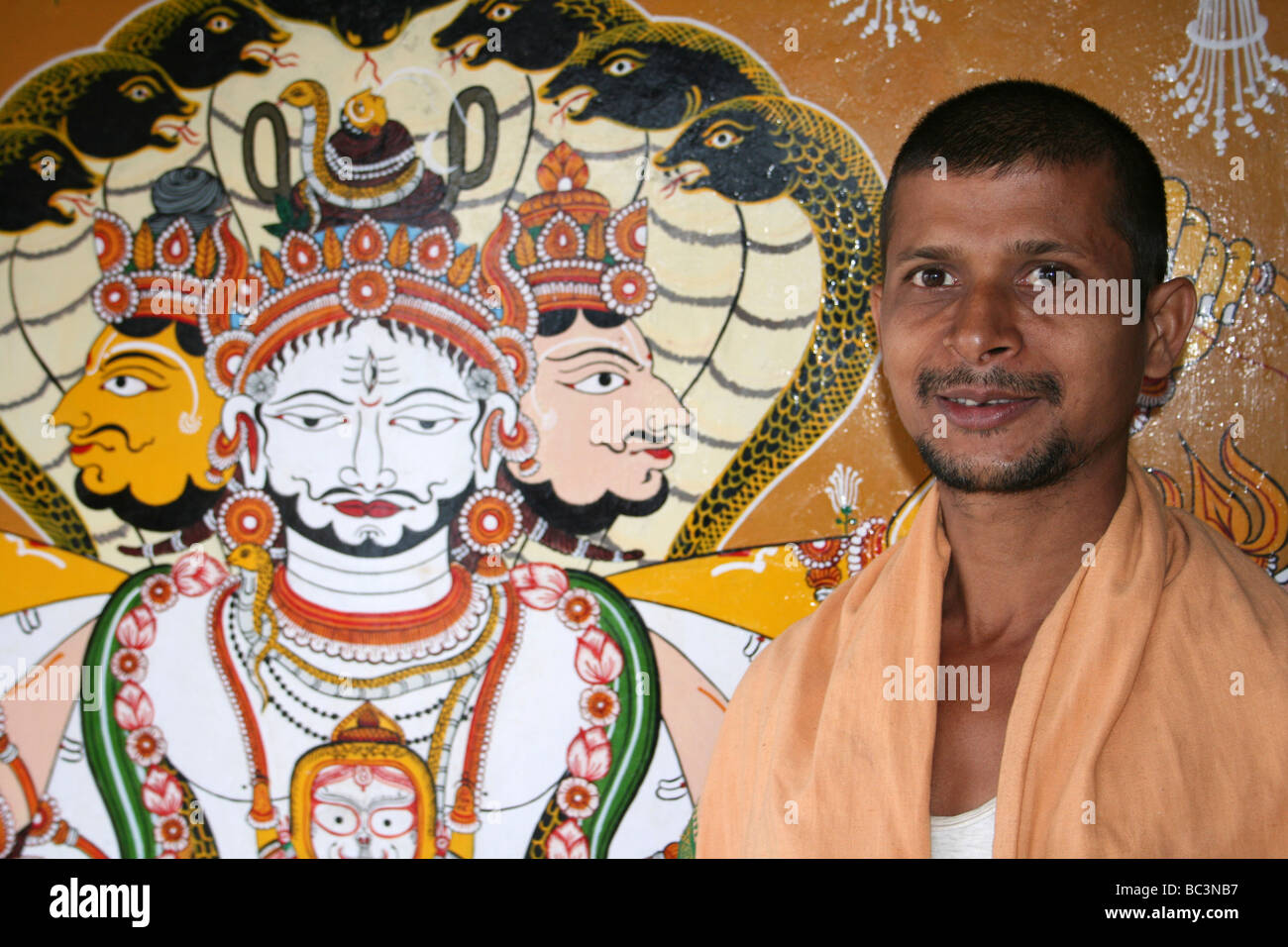 Sacerdote indio Besiside Pintura de la Trimurti de los tres dioses hindúes, Templo Jagganath, Koraput, India Foto de stock