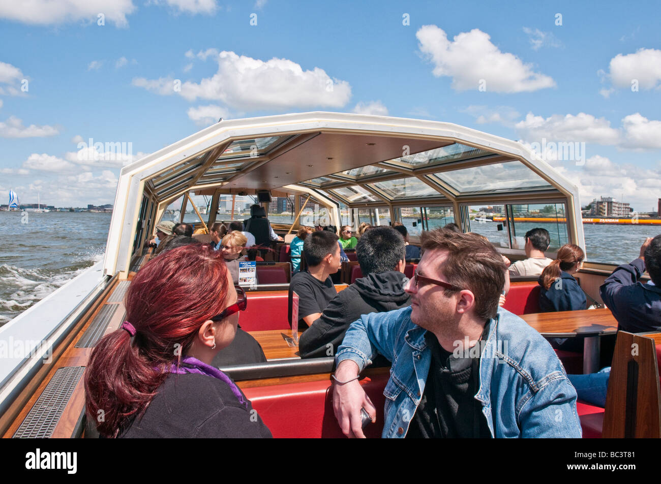 Los turistas de excursión en un autobús del canal en el Het IJ Foto de stock