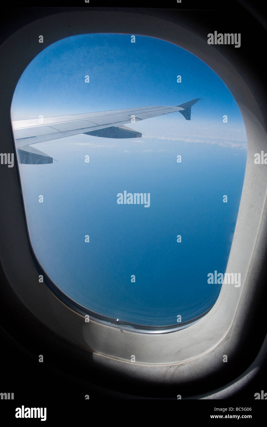 Vista de alas de avión a través de la ventana, mientras que en vuelo en altitud. Foto de stock