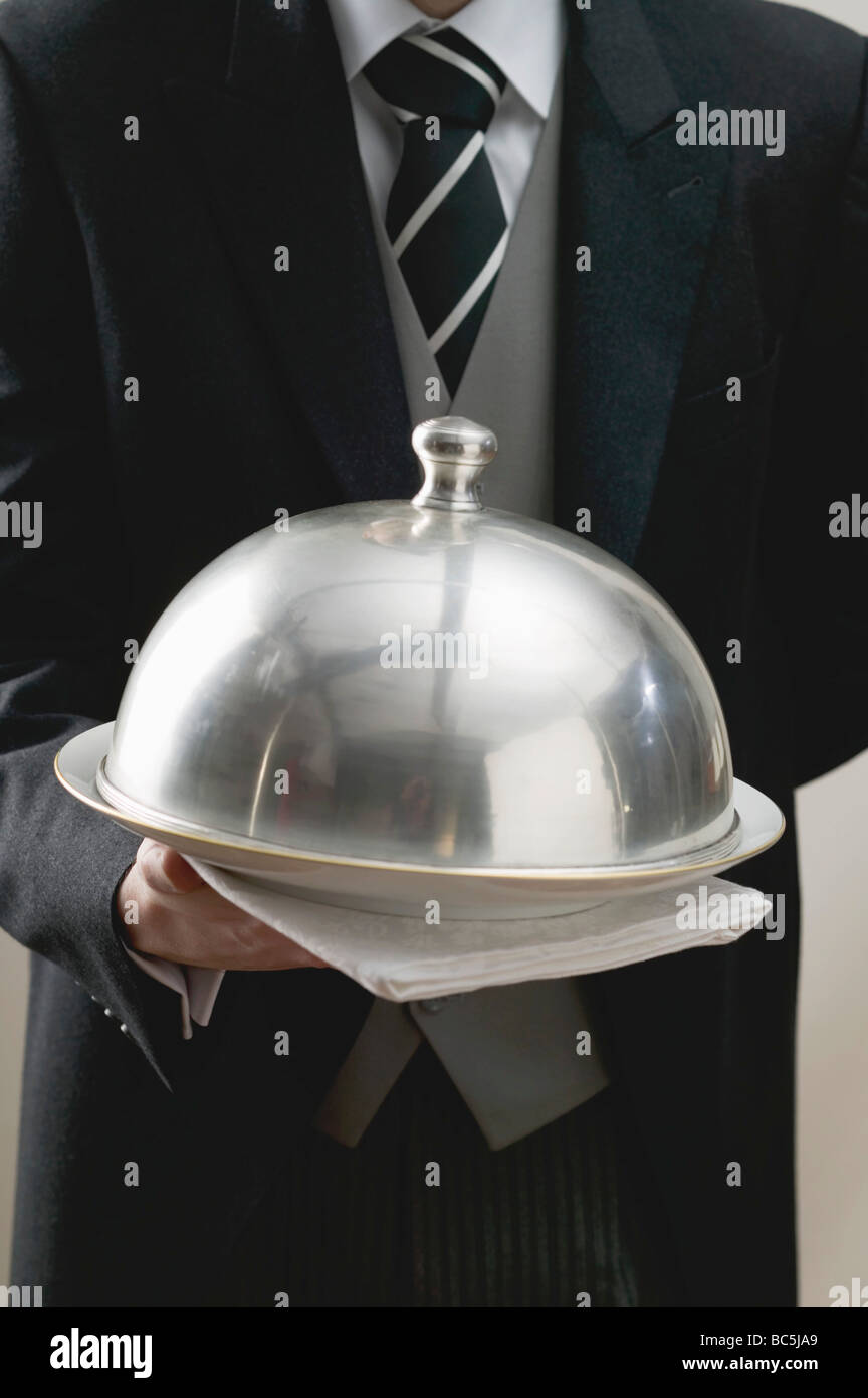 El camarero sirve plato bajo la cubierta del domo Fotografía de stock -  Alamy