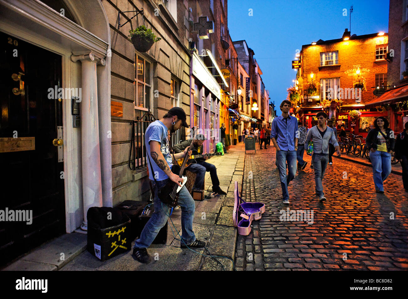Banda busking en calle adoquinada de la zona de vida nocturna de Temple Bar Dublín, República de Irlanda Foto de stock