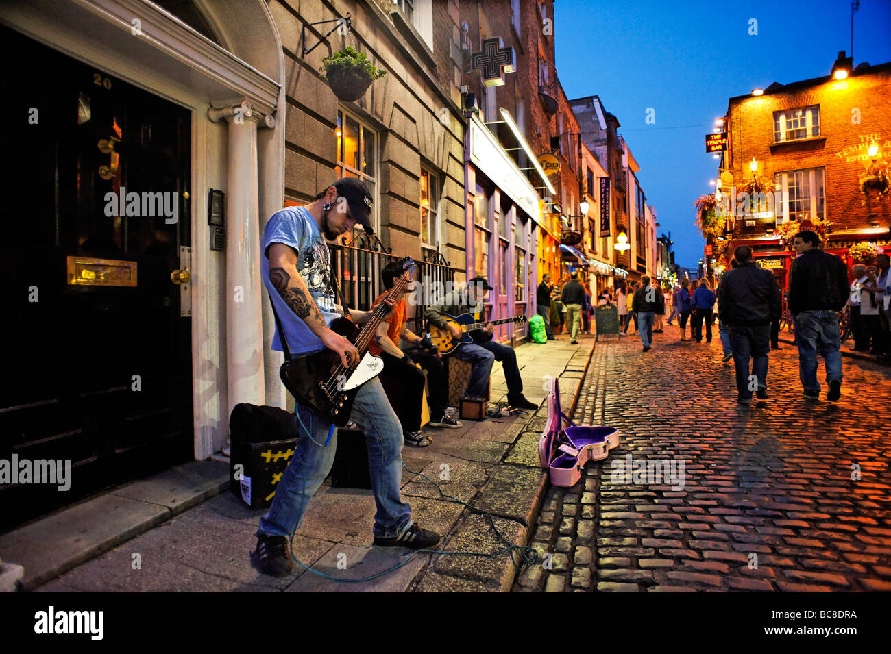 Banda busking en calle adoquinada de la zona de vida nocturna de Temple Bar Dublín, República de Irlanda Foto de stock